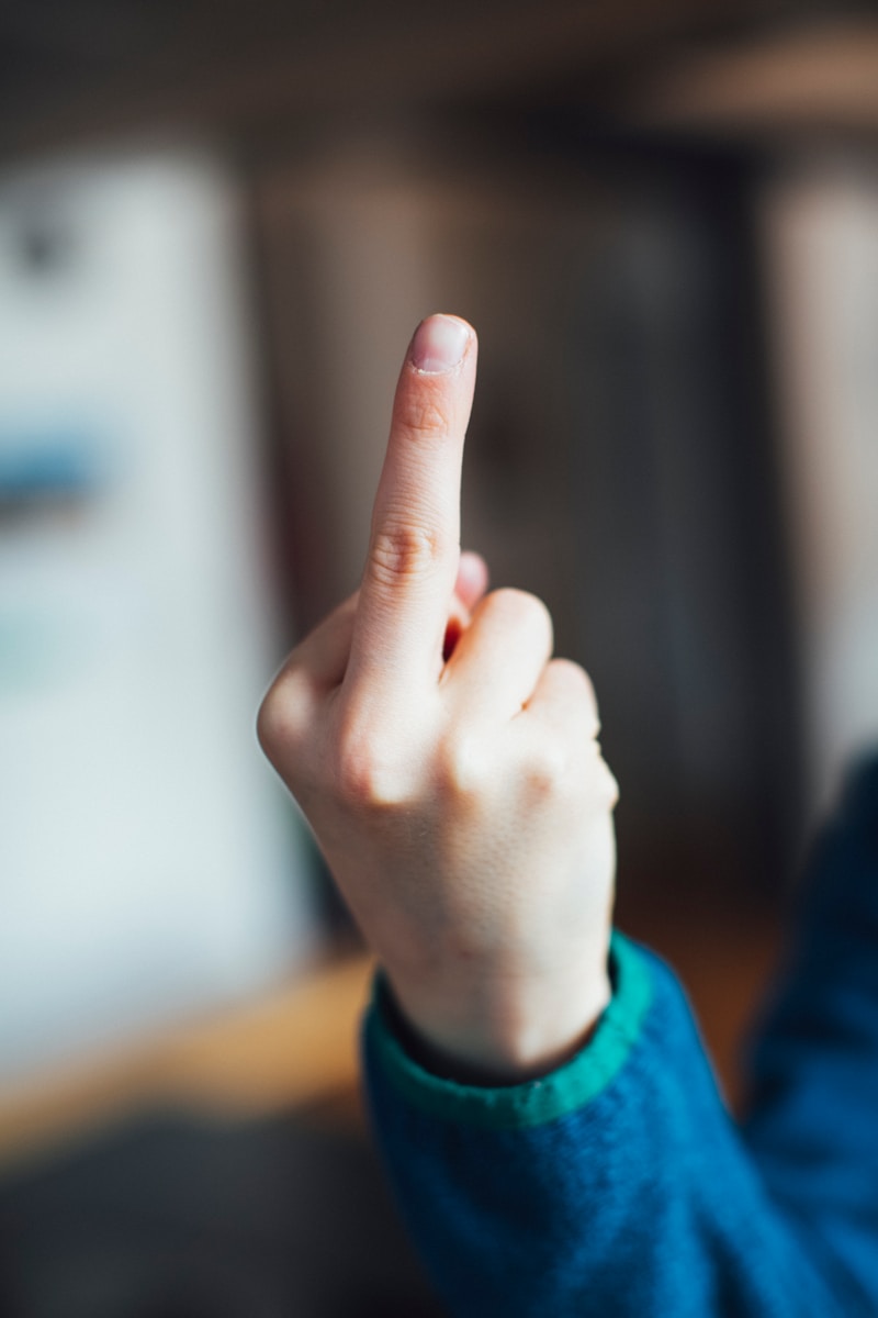 Photo by Markus Spiske person in blue long sleeve shirt showing right middle finger