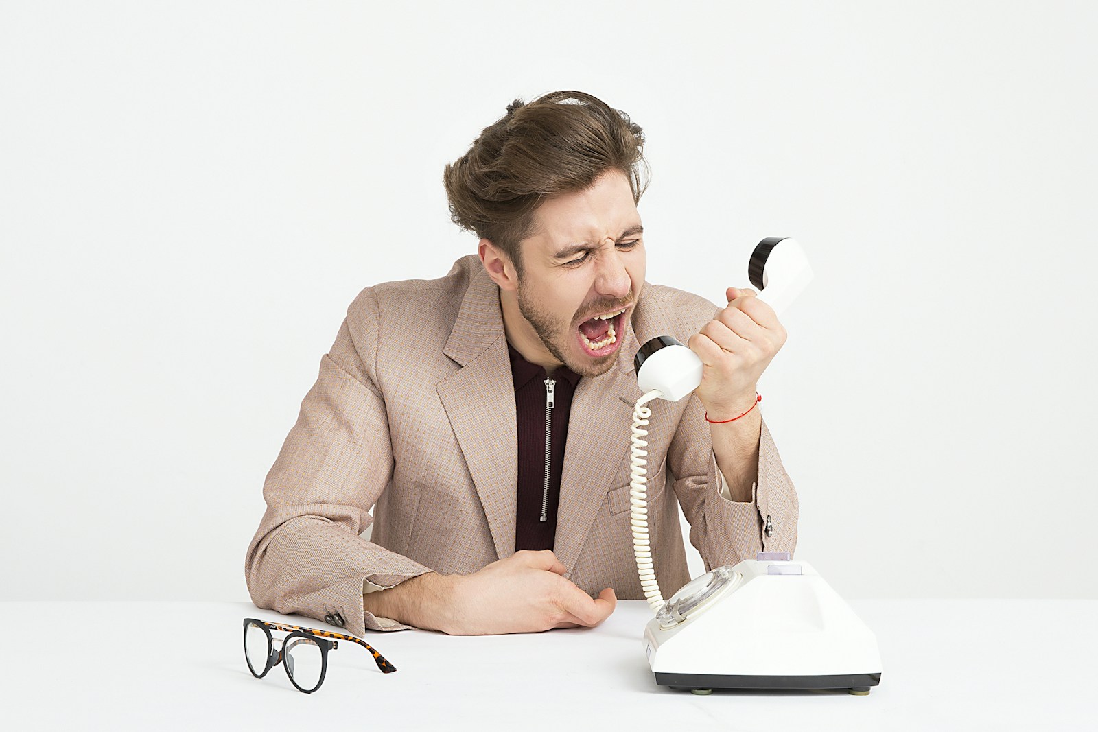 Photo by Icons8 Team man holding telephone screaming